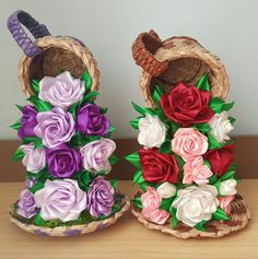 two baskets filled with flowers sitting on top of a wooden table next to each other