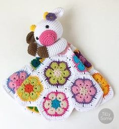 a crocheted cow sitting on top of a white table next to a wall