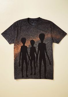 a t - shirt with the silhouettes of three aliens against a background of stars