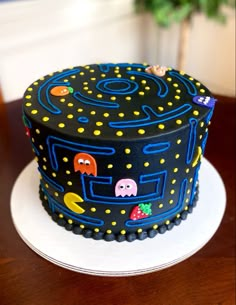 a black cake with pacman on it sitting on top of a table