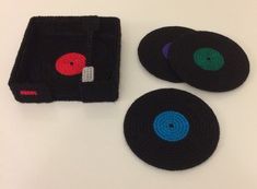 three pieces of black crocheted cloth with red, blue and green circles on them