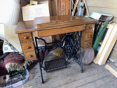 an old sewing machine sitting on top of a wooden table next to books and other items