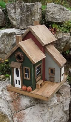 a bird house sitting on top of a rock