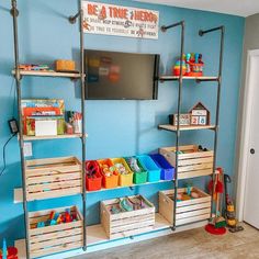 there is a television on the wall in this child's playroom with toys