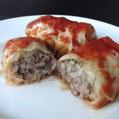 some food that is cut in half and sitting on a white plate with red sauce