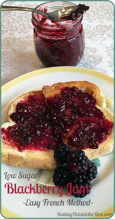 a piece of bread with jam on it and some blackberries next to it in front of a jar