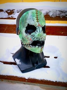 a halloween mask is sitting in the snow