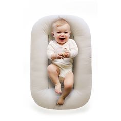 a baby is laying down on a pillow that looks like it's smiling at the camera