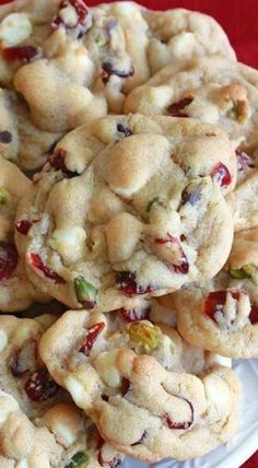 white chocolate cranberry cookies stacked on top of each other in front of a red tablecloth