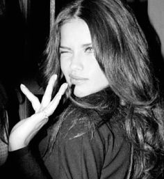 black and white photograph of a woman making the v sign