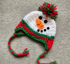 a crocheted snowman hat with red and green trim