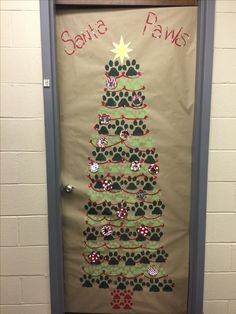 a door decorated to look like a christmas tree with paw prints on it and the words santa paws