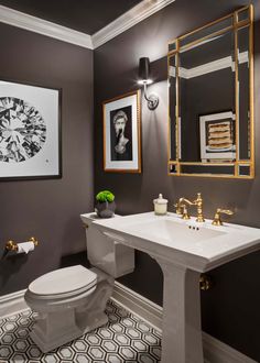 a white toilet sitting next to a sink in a bathroom under a framed picture on the wall