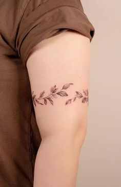 a woman's arm with leaves tattoo on the left side of her body,