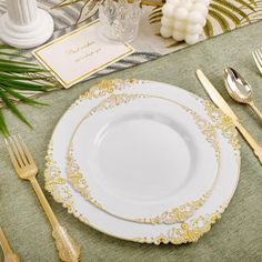 a place setting with gold and white plates