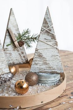 two wooden trees are sitting on top of some ice in a tray filled with snow