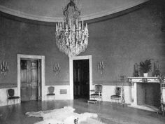 an old black and white photo of a room with chandelier