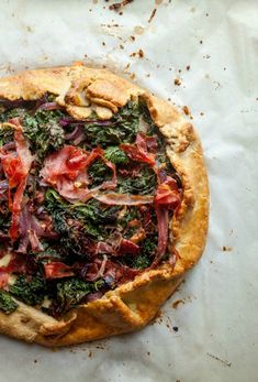 a pizza topped with lots of toppings sitting on top of a piece of paper