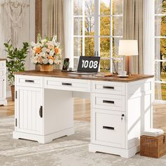 a white desk with drawers and a clock on it in front of a large window