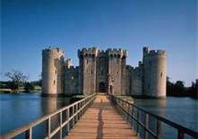 a long wooden walkway leading to a castle like structure on the water's edge