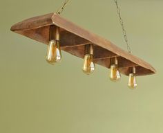 a wooden light fixture with five lights hanging from it's sides and an attached chain