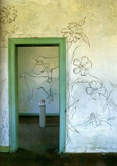 an open door to a room with drawings on the wall