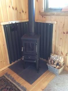 a black stove sitting in the corner of a room next to a rug and window