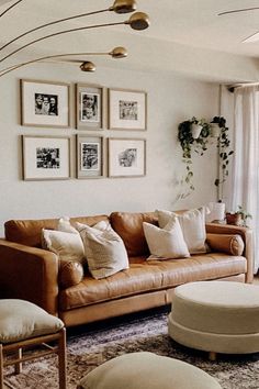 a living room filled with lots of furniture and pictures on the wall above it's windows