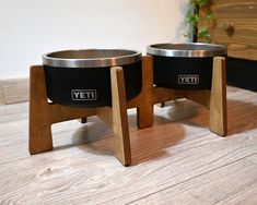 two metal bowls sitting on wooden stands next to each other