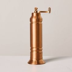 an old fashioned brass soap dispenser on a white surface