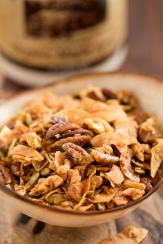 a bowl filled with granola sitting on top of a wooden table