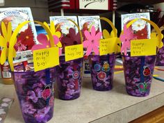 purple plastic cups filled with flowers and cards