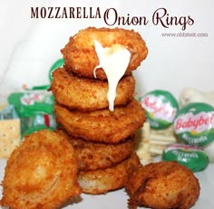 some onion rings are stacked on top of each other with mayonnaise being drizzled over them