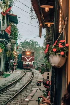 a train traveling down tracks next to a building