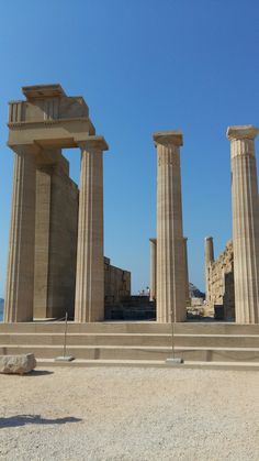 some very tall stone pillars in the sand