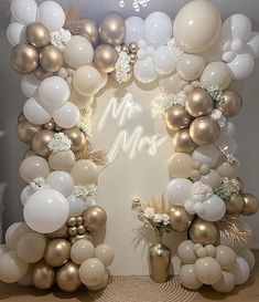 a white and gold balloon arch with balloons