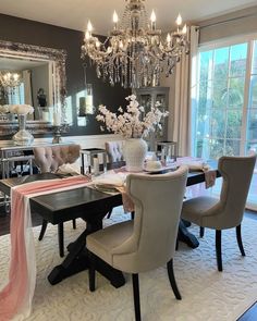 the dining room table is decorated for christmas with red and white decorations, silver chandelier, and candlesticks