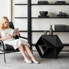 a woman sitting in a chair reading a book