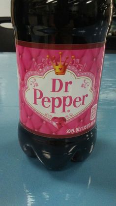 a bottle of dr pepper sitting on top of a blue table with a crown on it