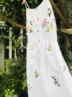 ❤ The white linen hand embroidered dress is very soft, skin friendly, breezy and comfortable. ❤ Item description: - A lovely dress with colourful embroidered wild flowers and bee motifs. You seem to be lost in a garden which full of fragrant flowers and strange grass. - Material: linen, coconut button, embroidery threads. - Environmentally friendly. - This dress is very useful, go with any outfit, that can be used to go to school, go out, go shopping. It is a perfect gift for yourself or your be Summer Floral Applique Embroidered Dress For Garden Party, White Floral Embroidery Dress For Garden Party, White Flower Shaped Summer Dress, Spring Bohemian Linen Dress With Floral Embroidery, Bohemian Spring Linen Dress With Floral Embroidery, White Floral Embroidery Sundress For Spring, White Floral Embroidered Sundress For Spring, Bohemian Linen Dress With Floral Embroidery, Bohemian Linen Dress With Floral Embroidery For Garden Party