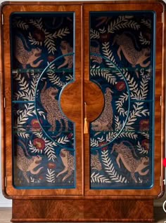 a wooden cabinet with an animal design on the front and side panels, painted in blue