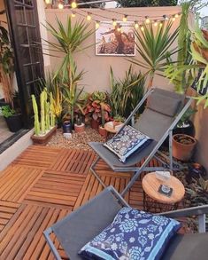 an outdoor patio with chairs and potted plants on the decking area, surrounded by greenery