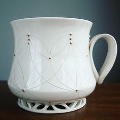 a white coffee cup sitting on top of a wooden table