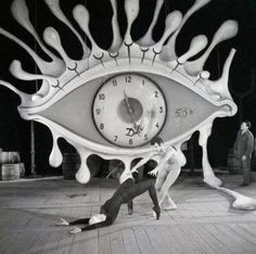 a man is standing in front of an eye clock