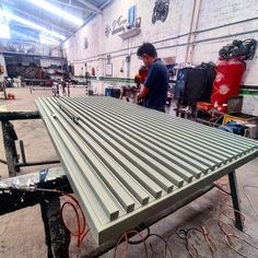 a man working on a metal structure in a factory