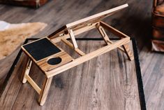 a small wooden table with a laptop on it and a mouse pad in the middle