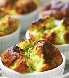 several muffins in white dishes with green toppings on the top and bottom