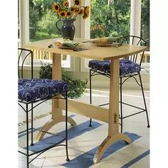 a dining room table with two chairs and sunflowers