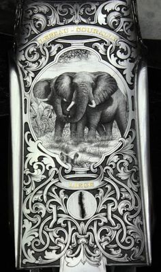 an elephant is engraved on the side of a metal box with ornate designs and scrolls