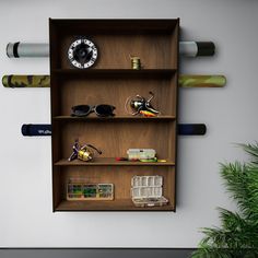 a wooden shelf with sunglasses and other items on it next to a potted plant